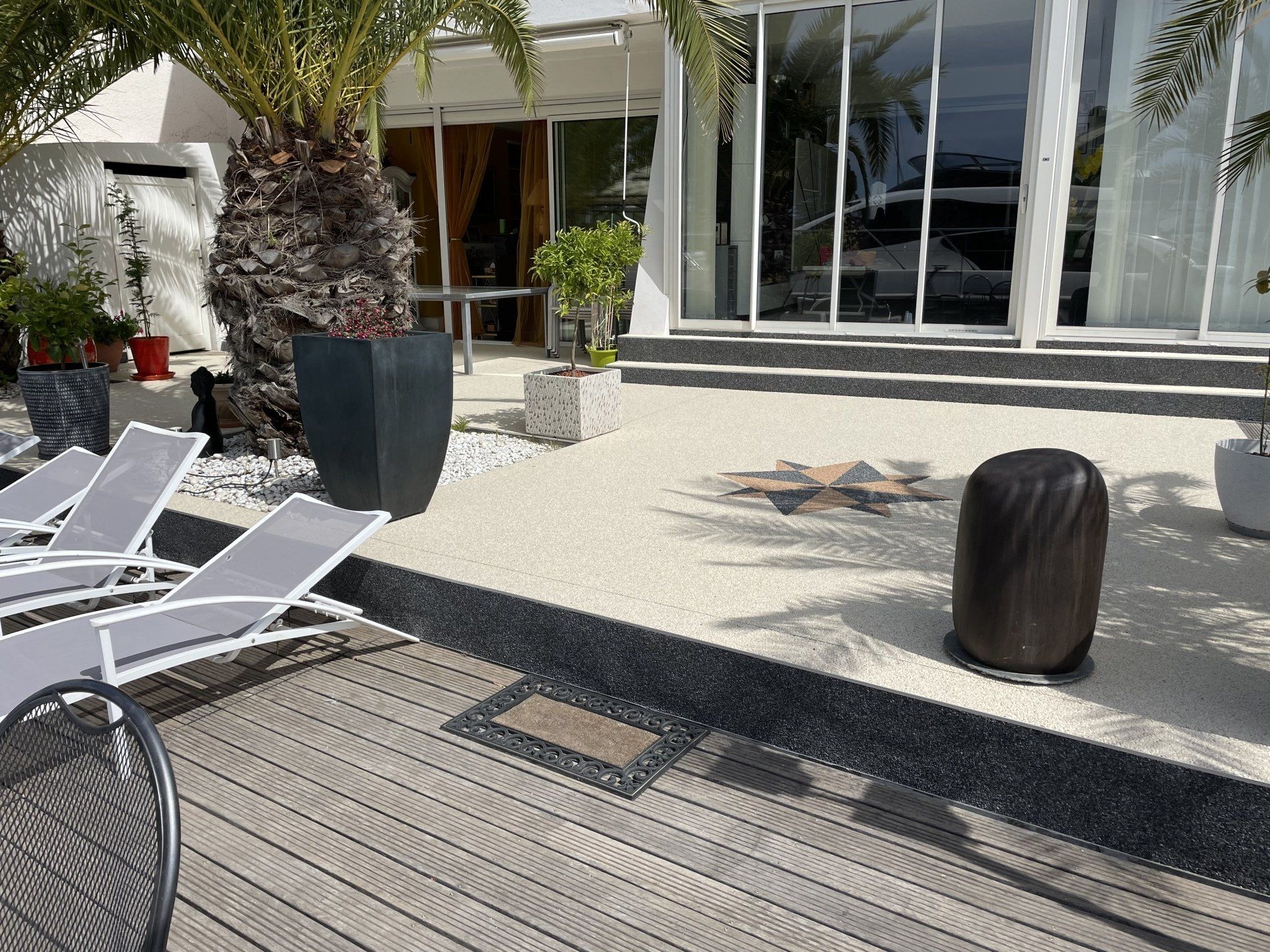 Super résine décorative coulée devant maison avec grandes baies vitrées, motif rose des vents.