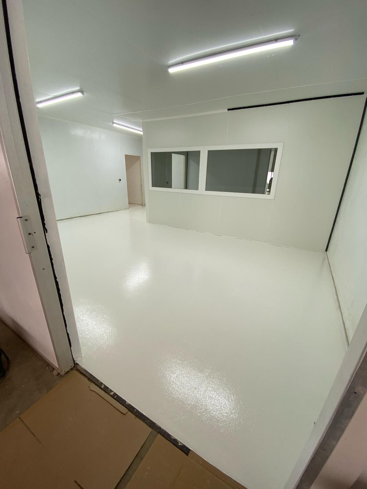 Sol intérieur lisse et brillant, en résine, dans une pièce vide.