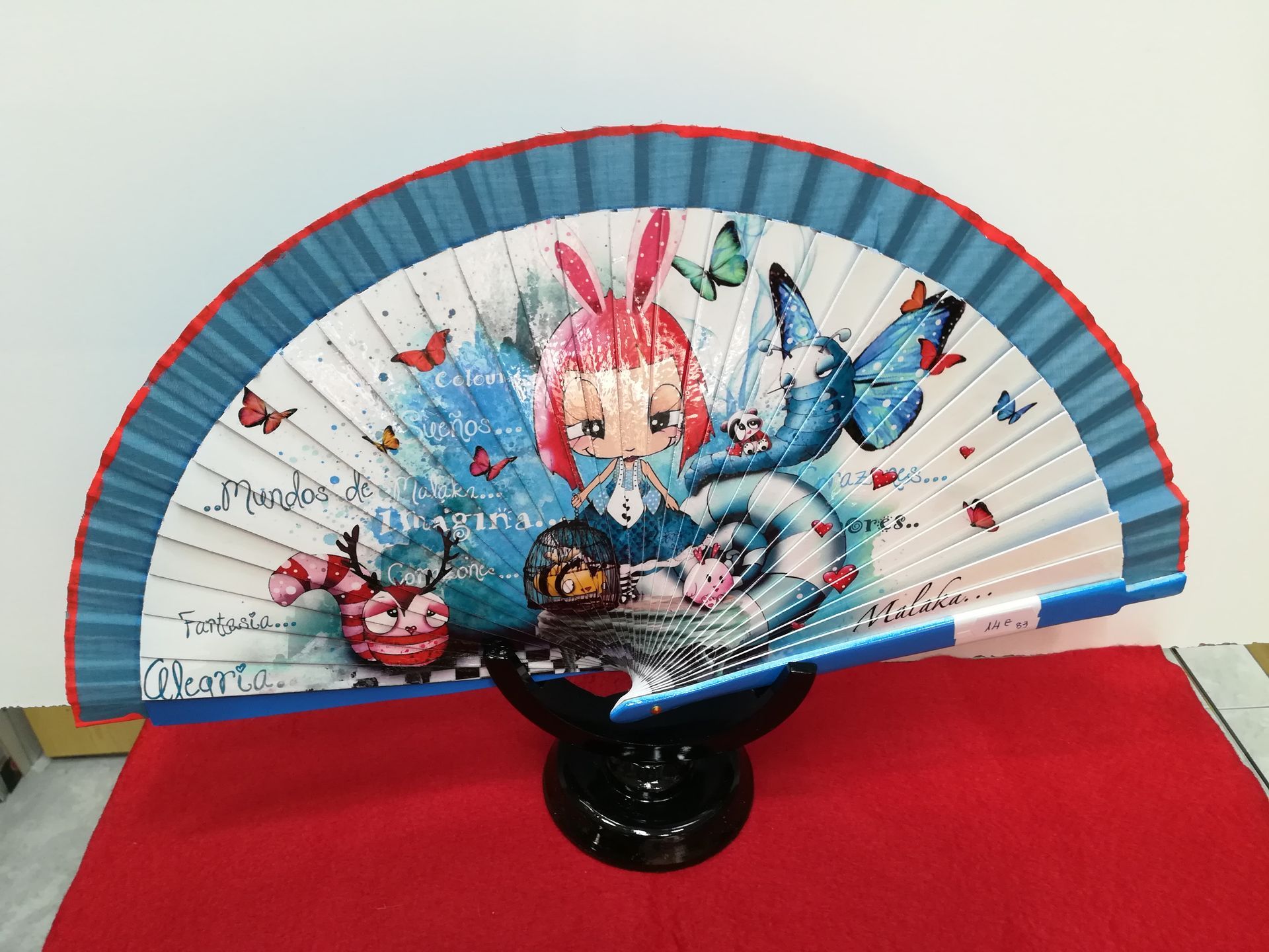 Un abanico con una imagen de Alicia en el país de las maravillas.