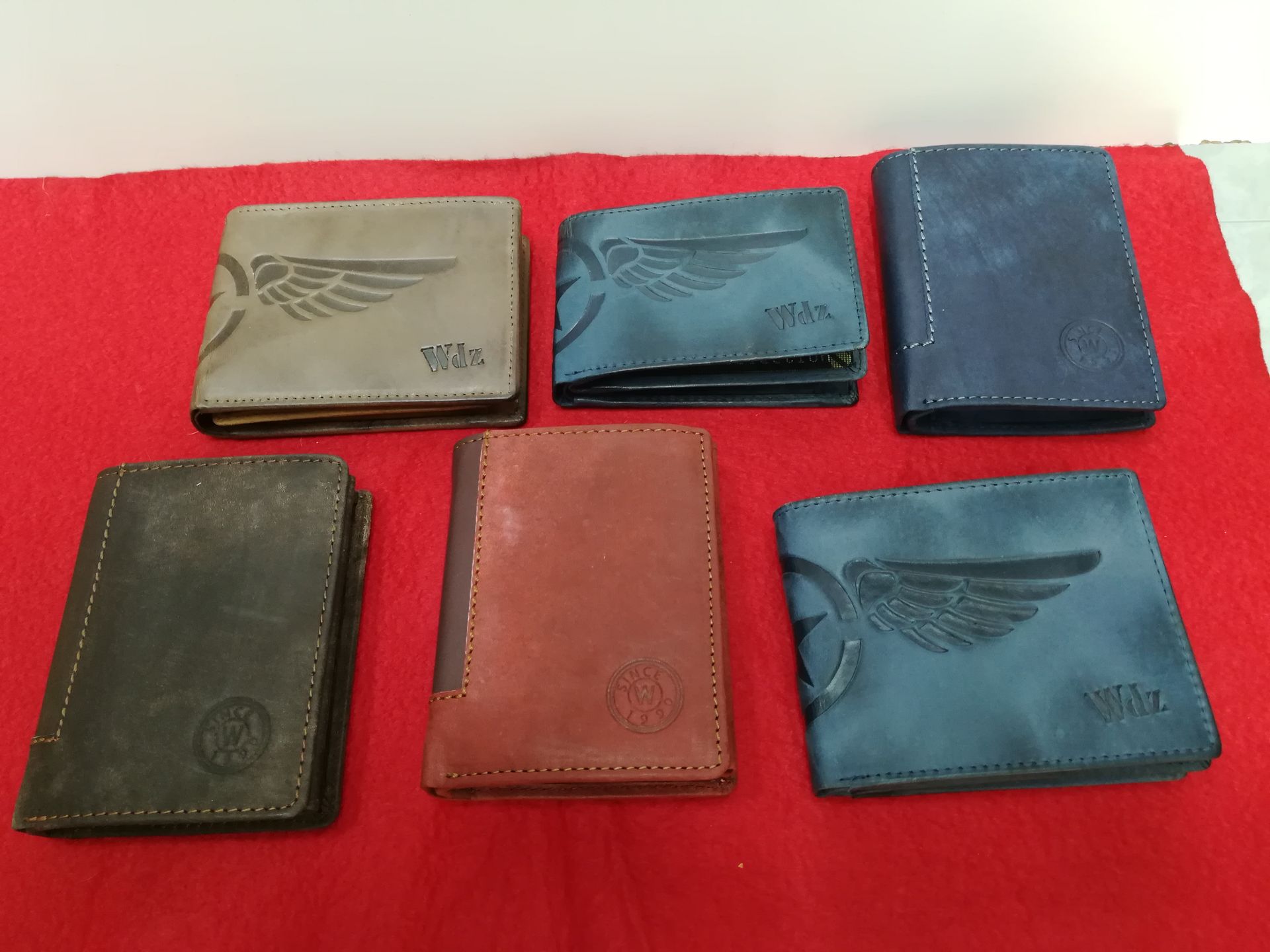 Un grupo de carteras están alineadas sobre un paño rojo.