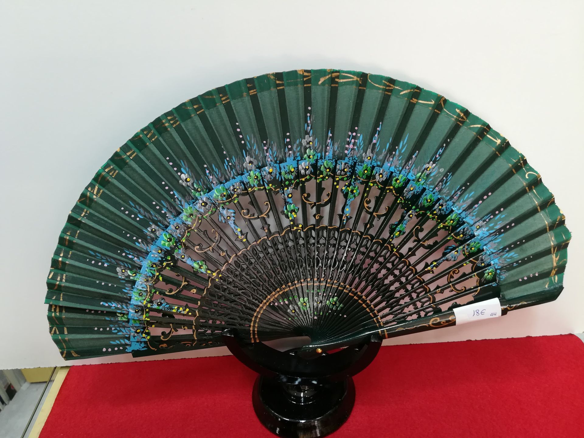 Un fanático verde está sentado en una alfombra roja