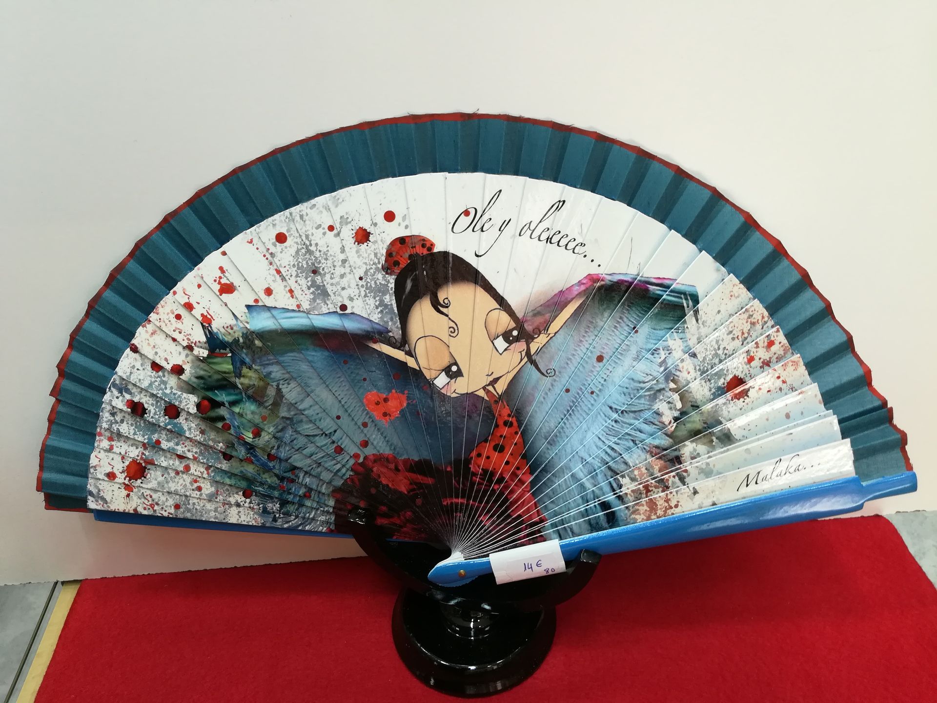 Un abanico azul y blanco con una mariquita.