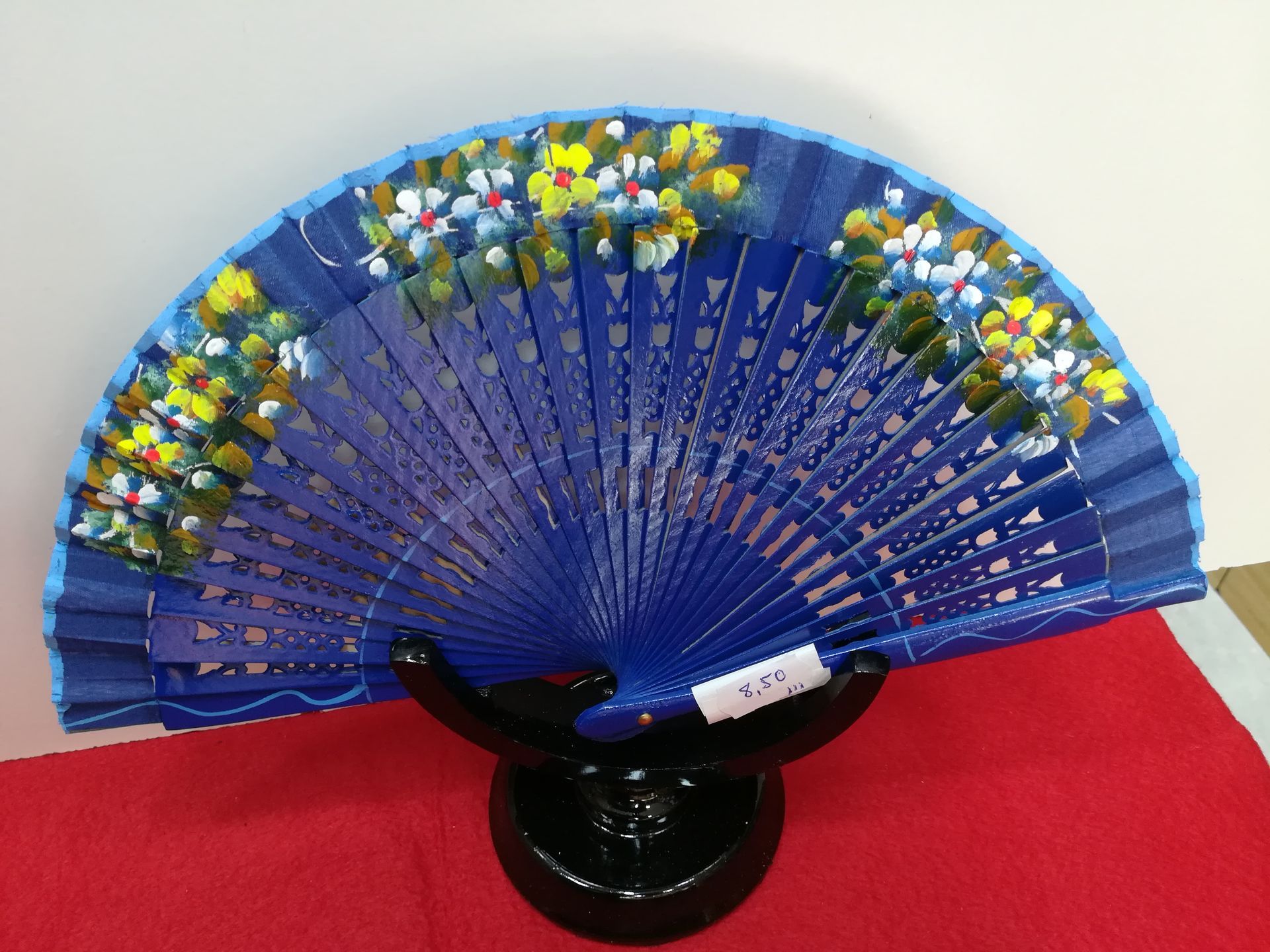 Un abanico azul con flores pintadas.