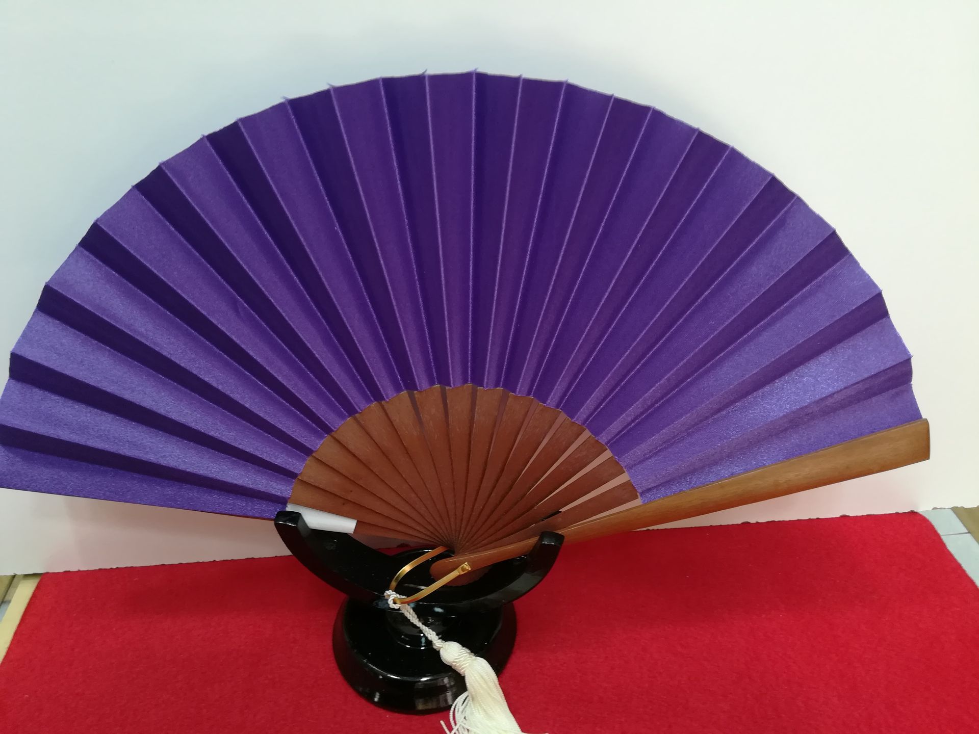 Un fanático morado está sentado en una alfombra roja.