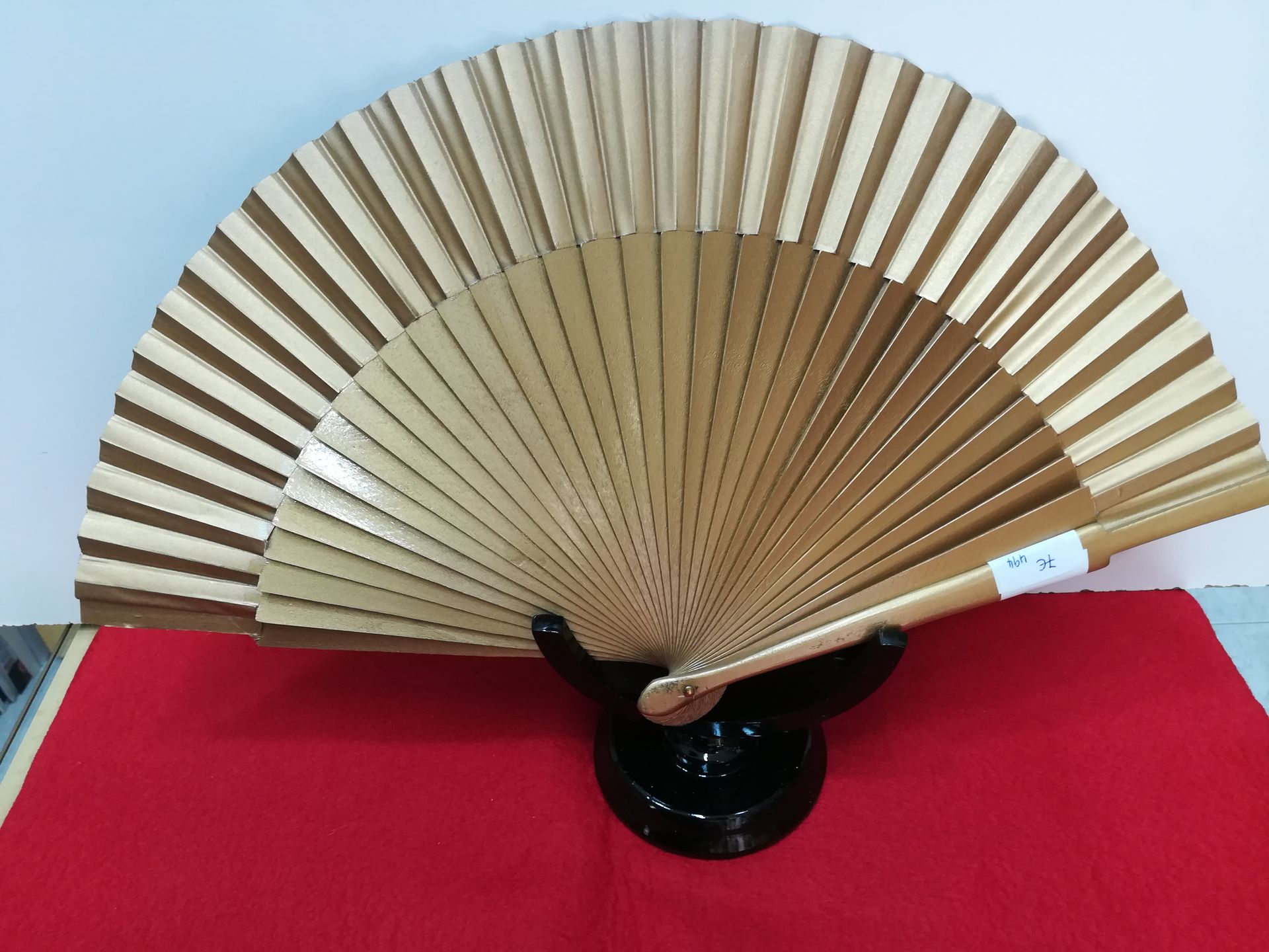 Un fan está sentado encima de una tela roja.