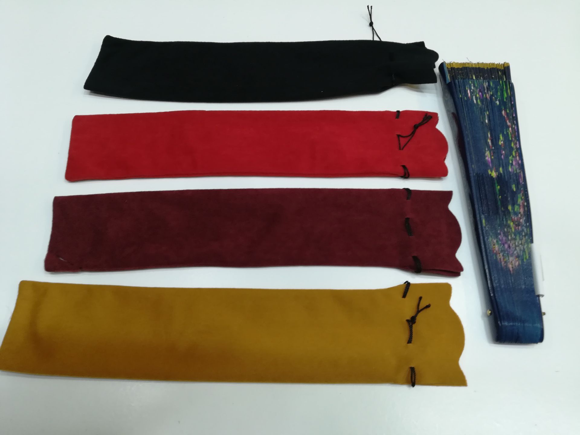 Cuatro telas de diferentes colores están alineadas sobre una superficie blanca.