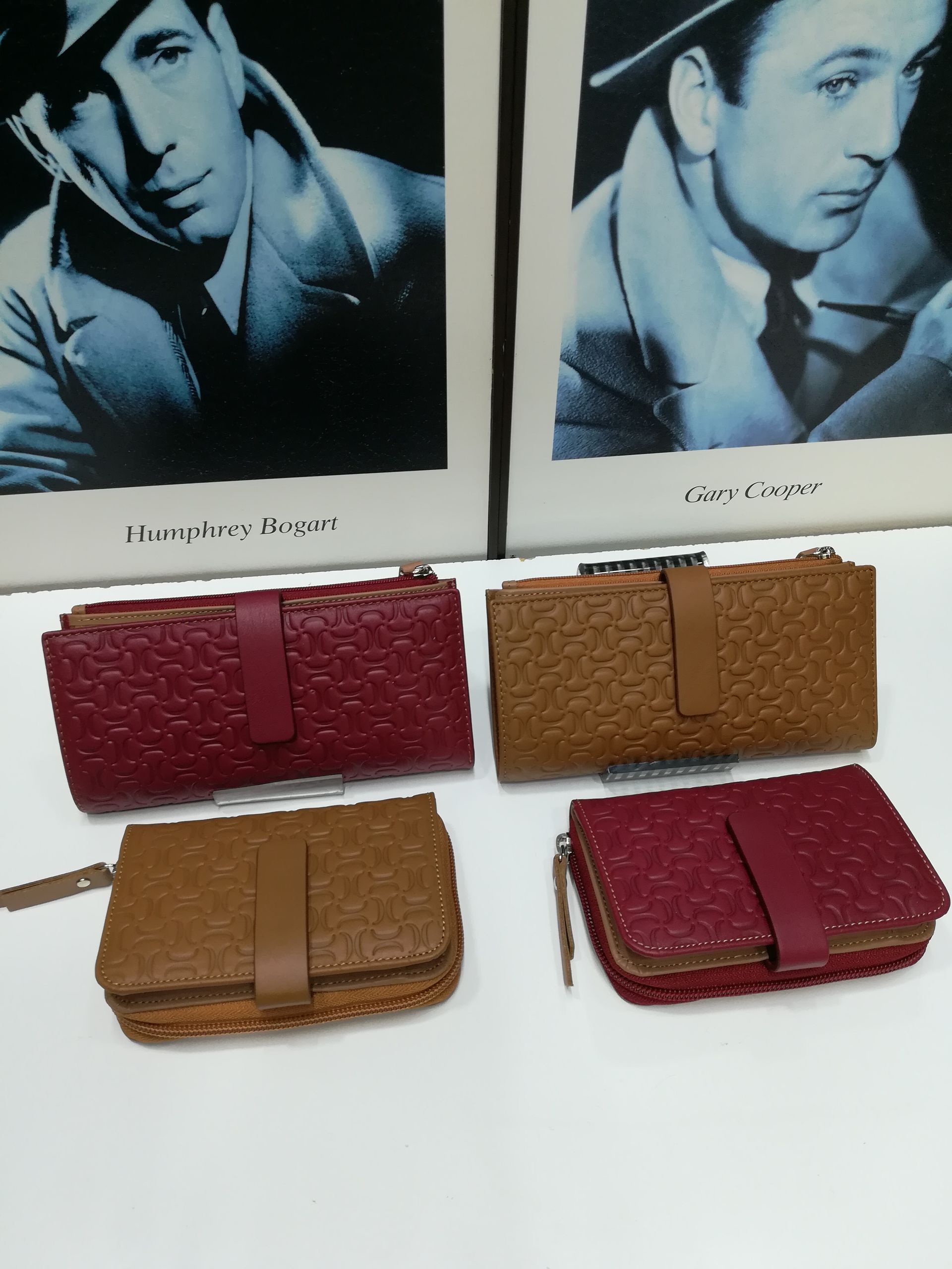 Un par de carteras están sobre una mesa junto a dos fotografías de hombres.