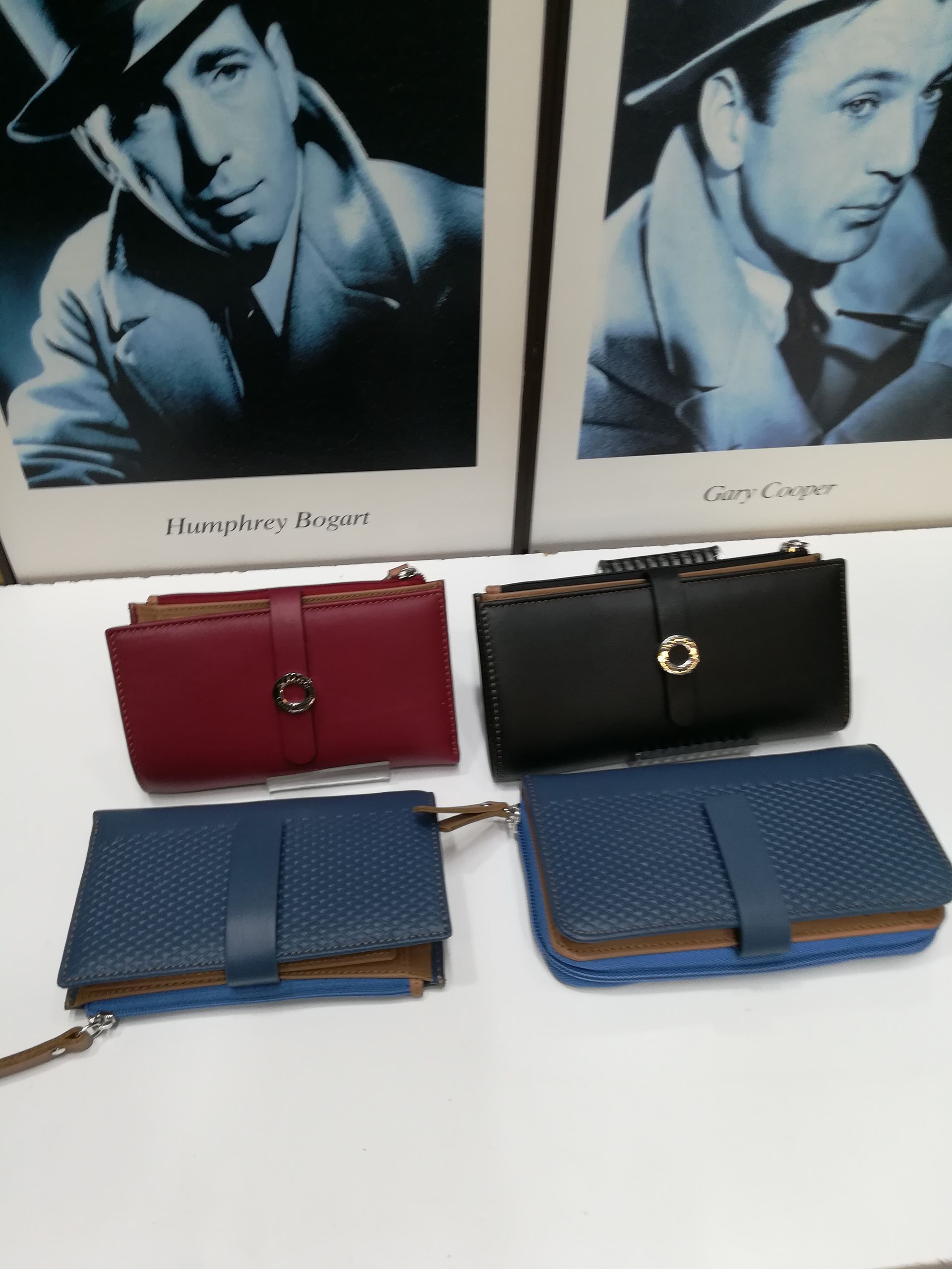 Tres carteras están sobre una mesa frente a una foto de Henry Bogart.
