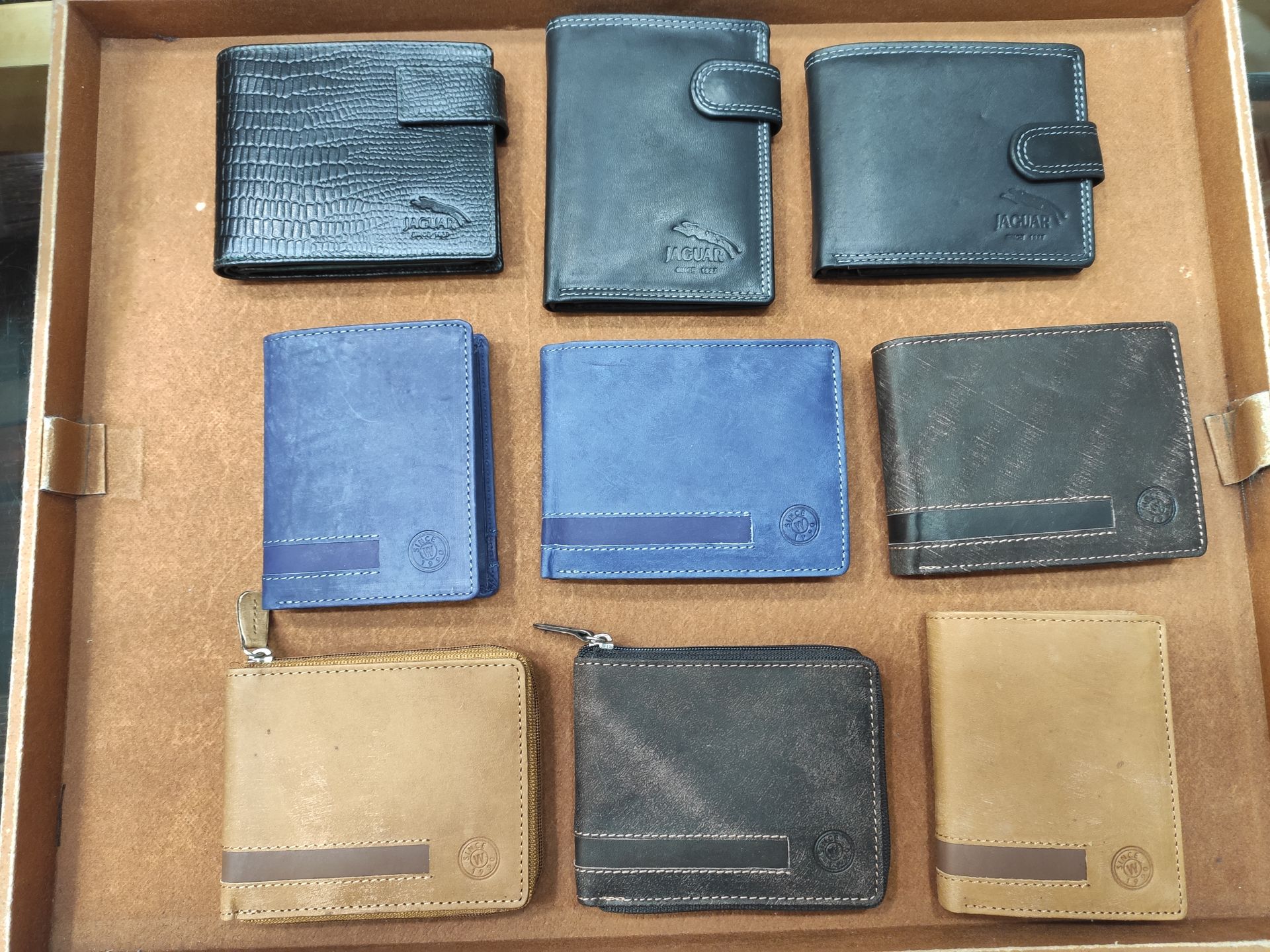 Varias carteras están alineadas en una bandeja de madera