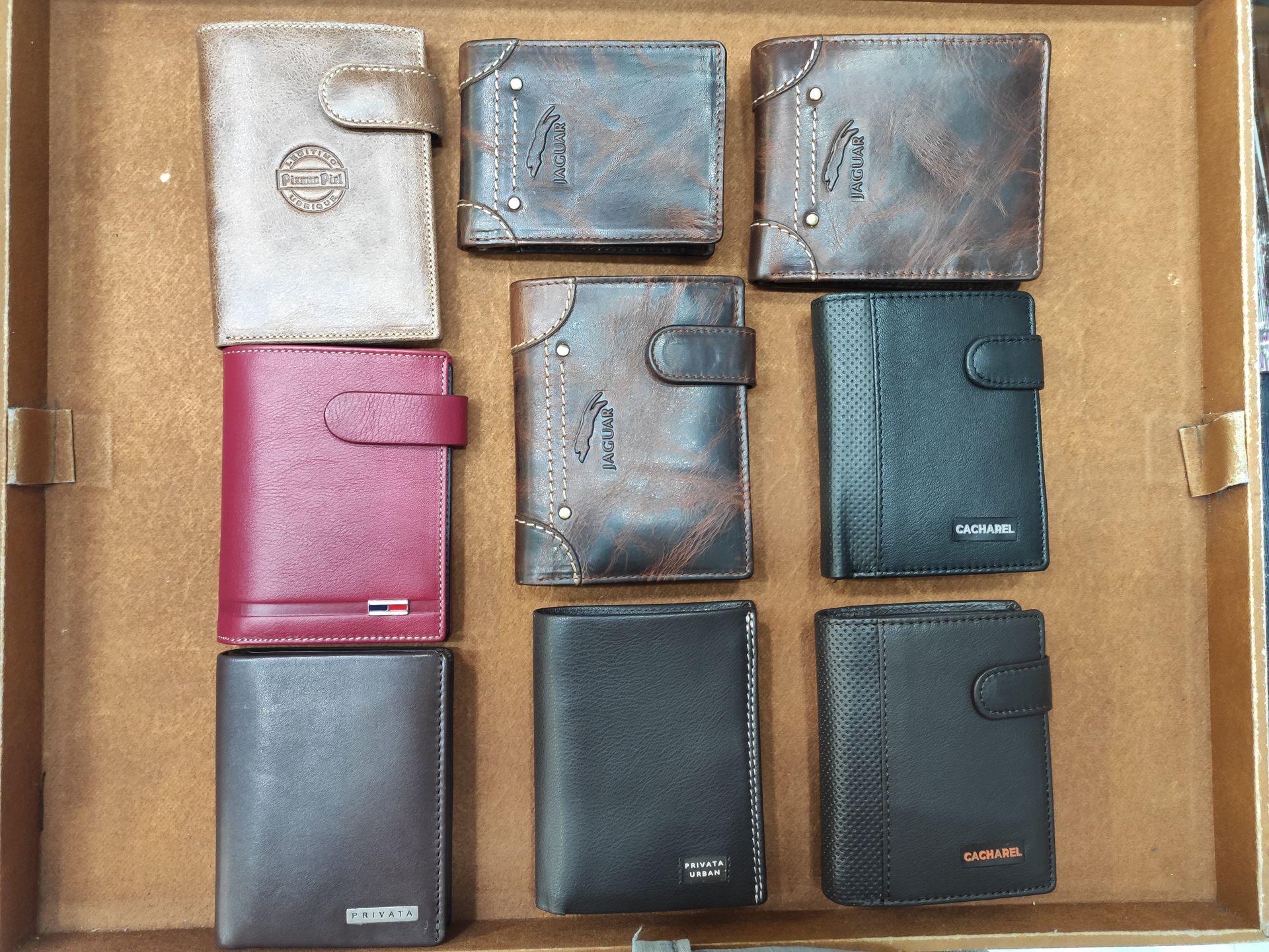 Un montón de carteras están alineadas en una caja de madera