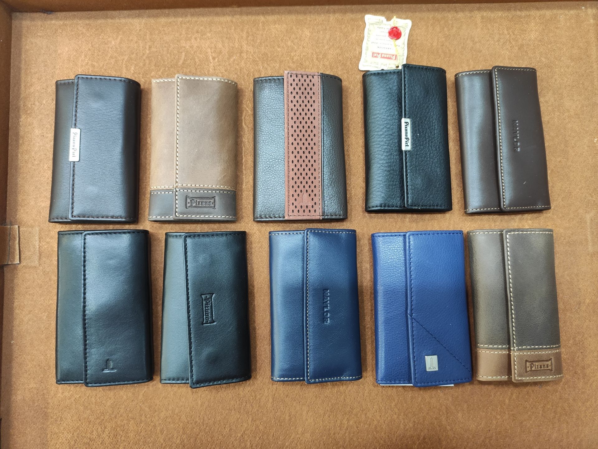 Un montón de carteras de diferentes colores están alineadas sobre una mesa.