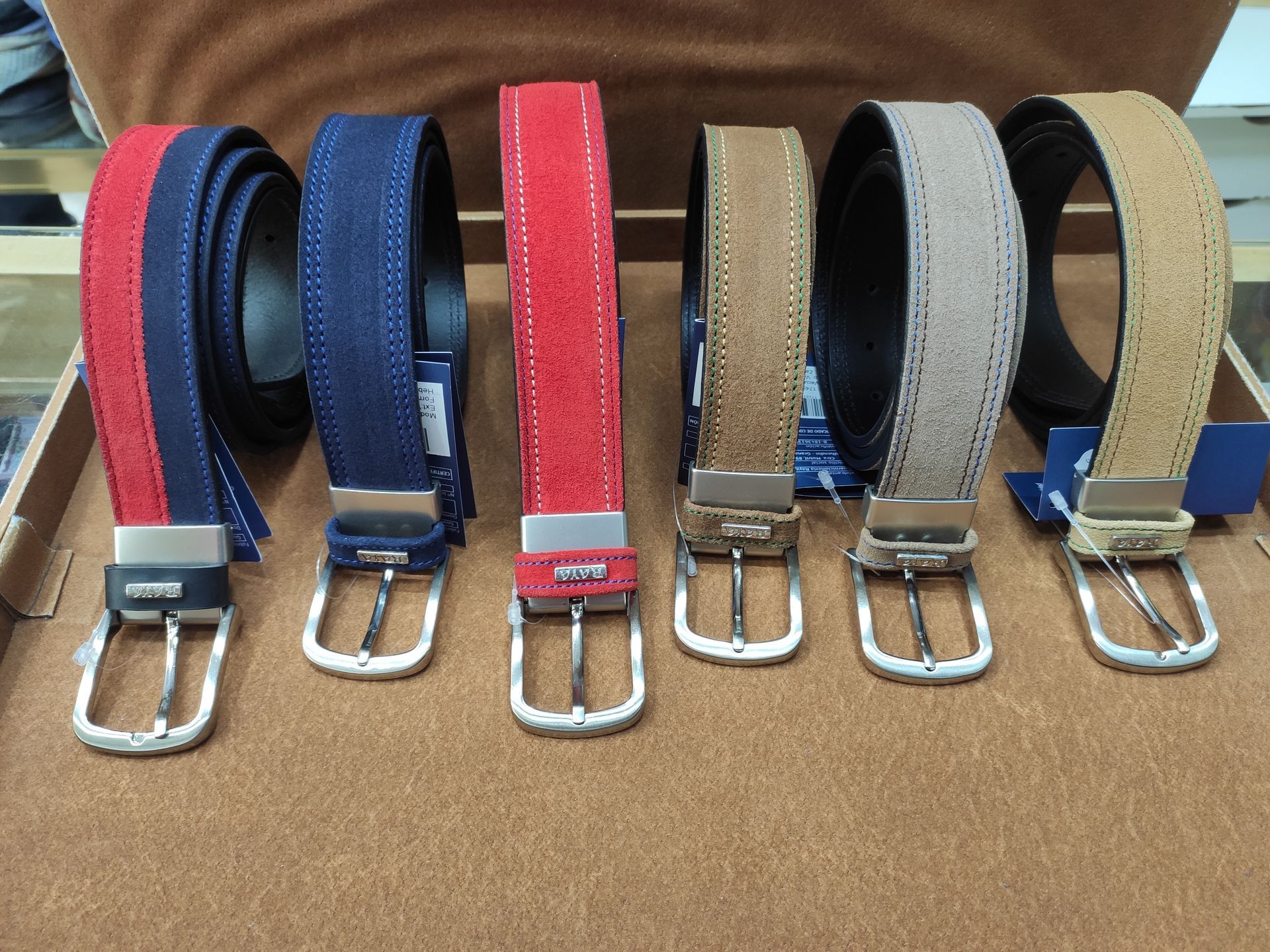 Varios cinturones de diferentes colores están alineados sobre una mesa.