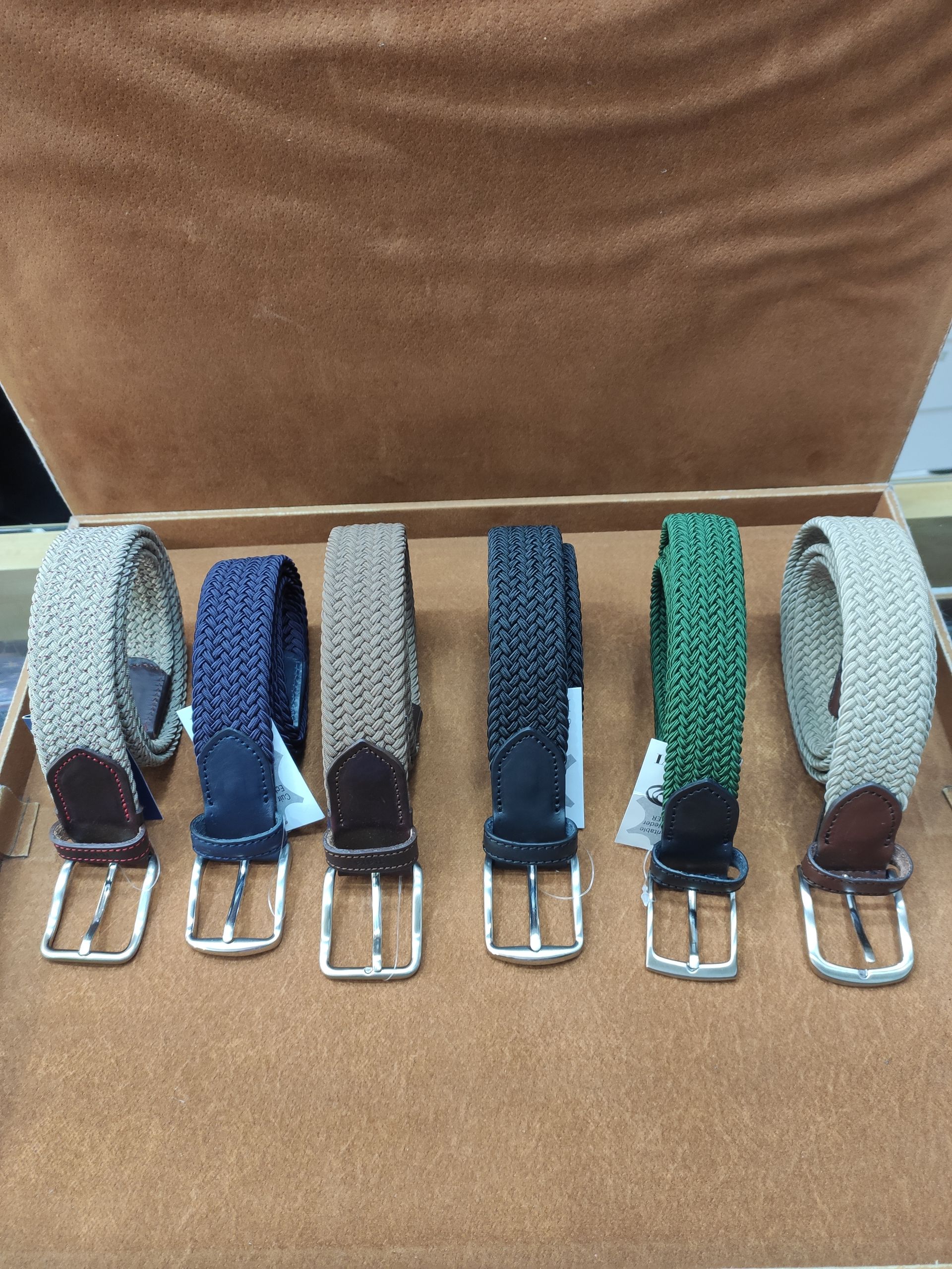 Cuatro cinturones de diferentes colores están alineados sobre una mesa.