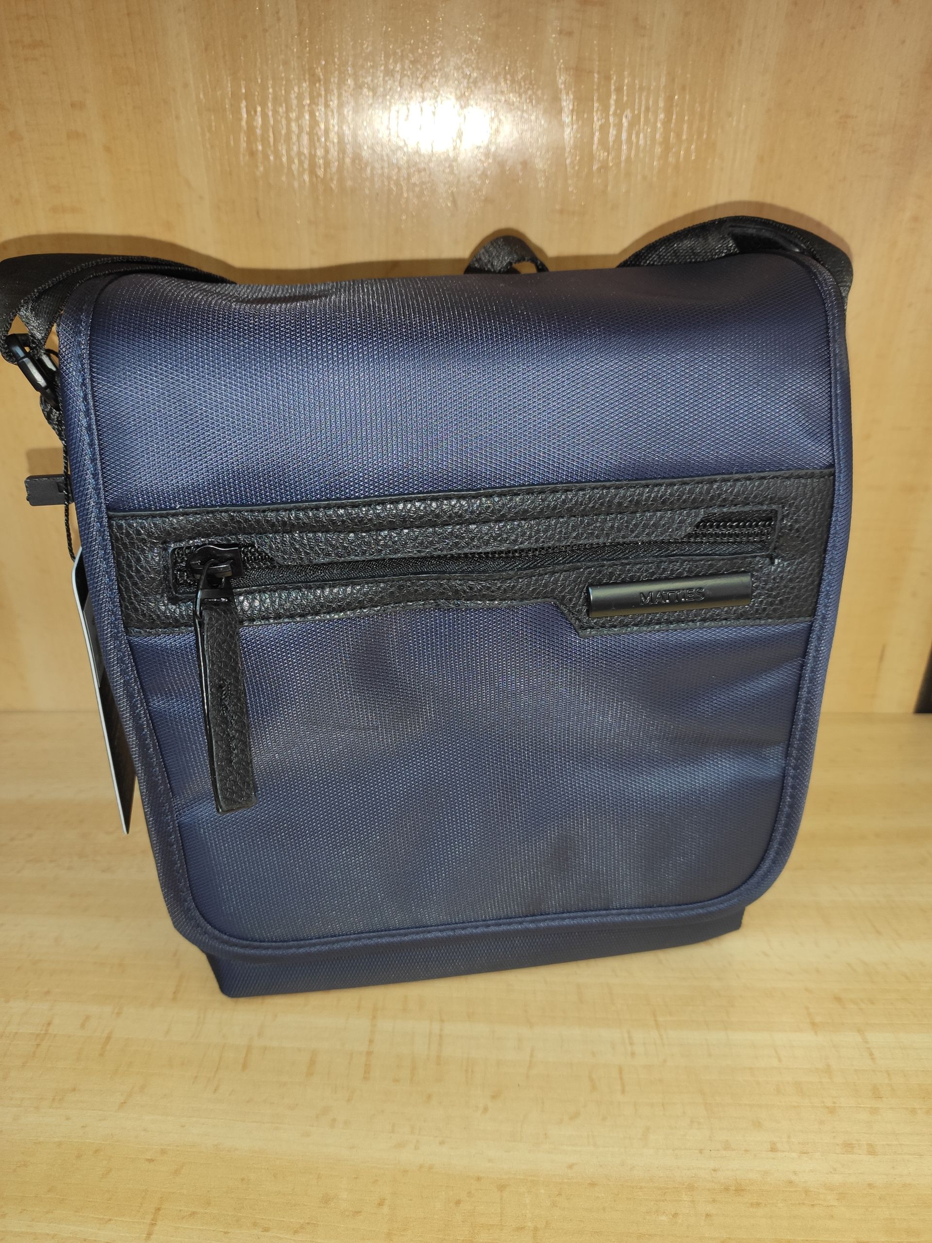 Una pequeña bolsa azul está sobre una mesa de madera.