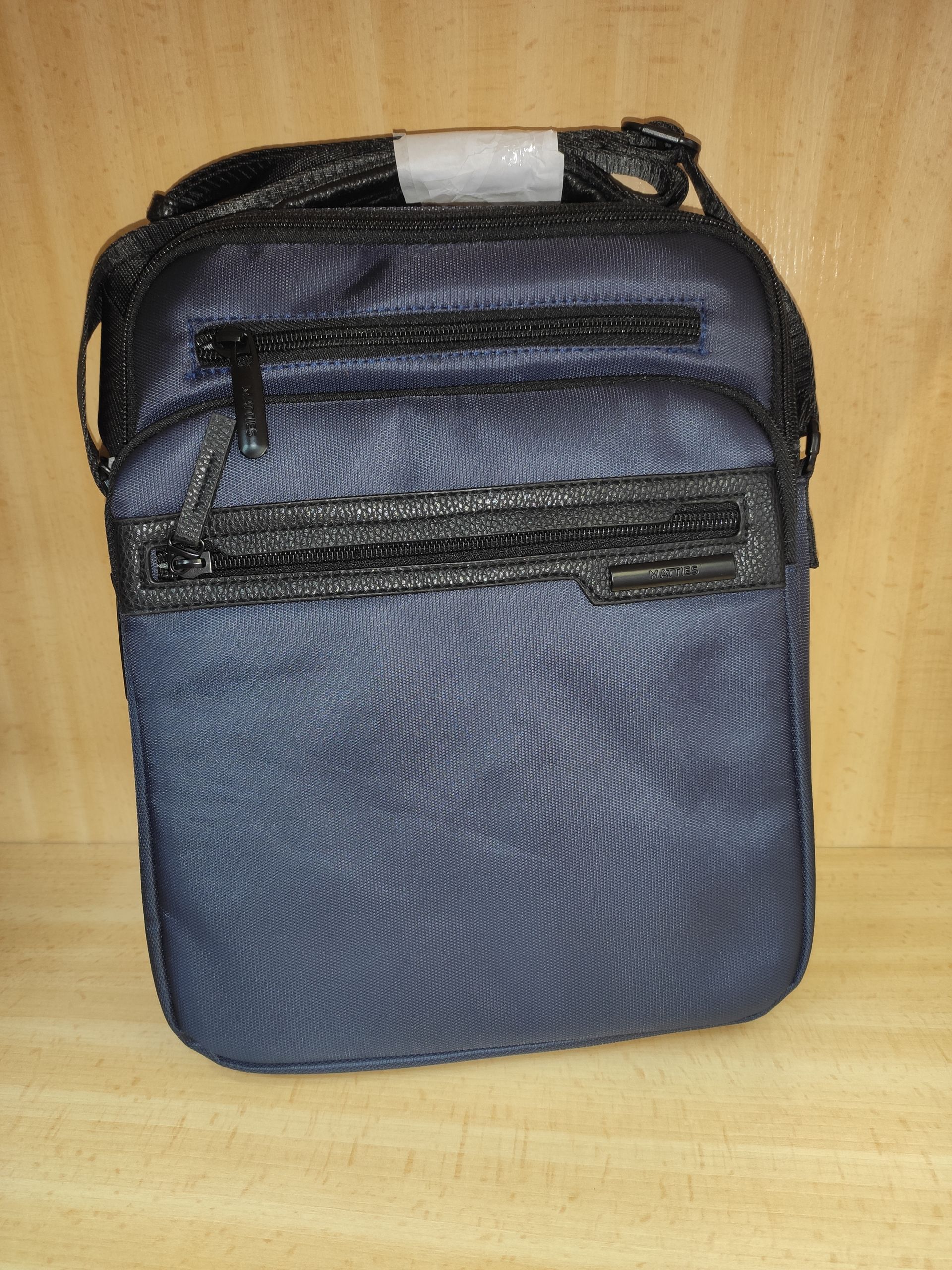 Una pequeña bolsa azul está sobre una mesa de madera.