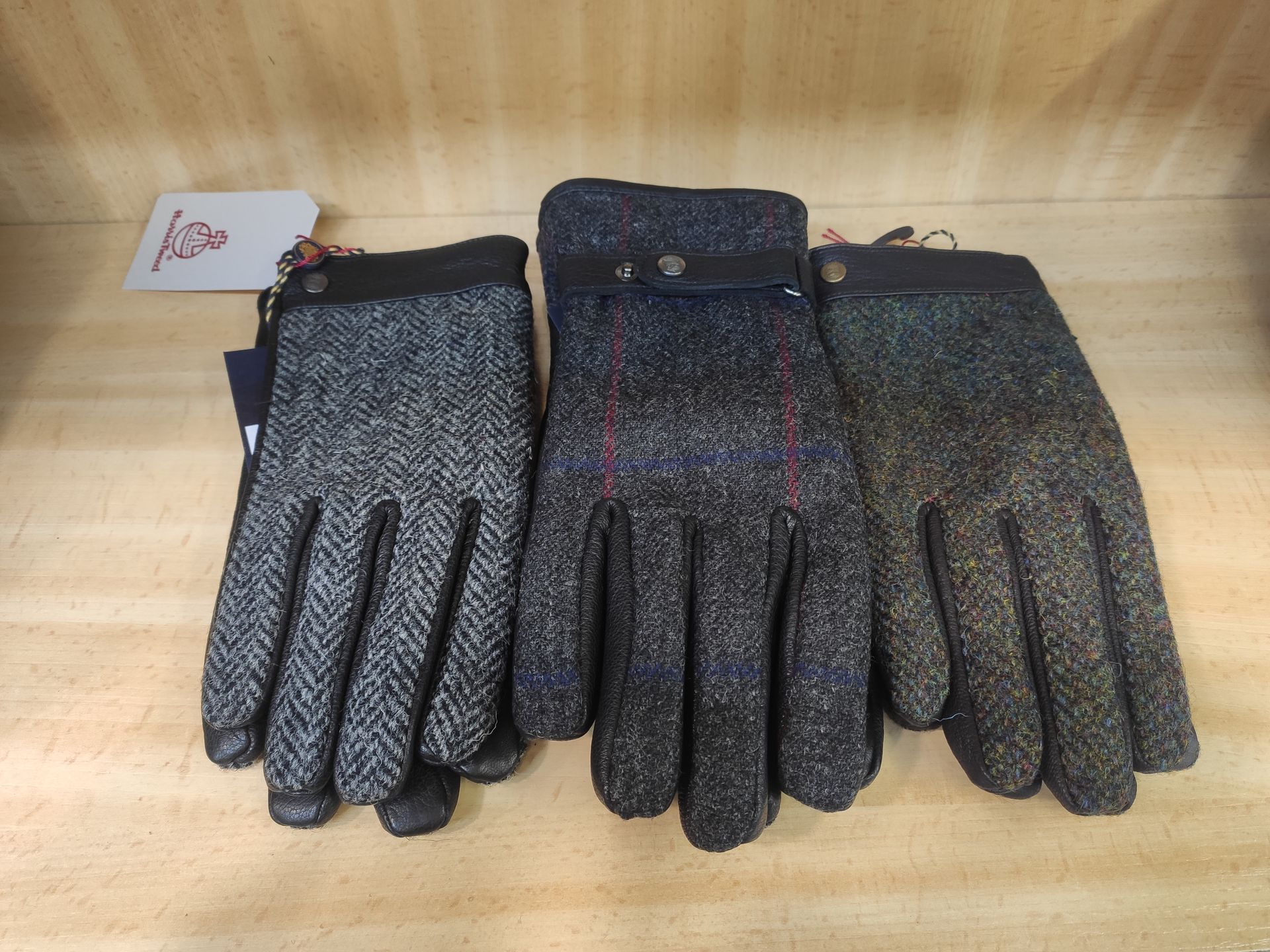 Tres pares de guantes están sobre una mesa de madera.