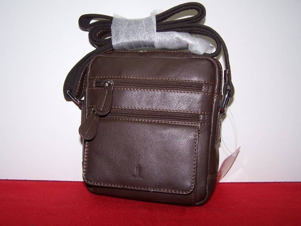 Un bolso mensajero de cuero marrón con una correa negra.