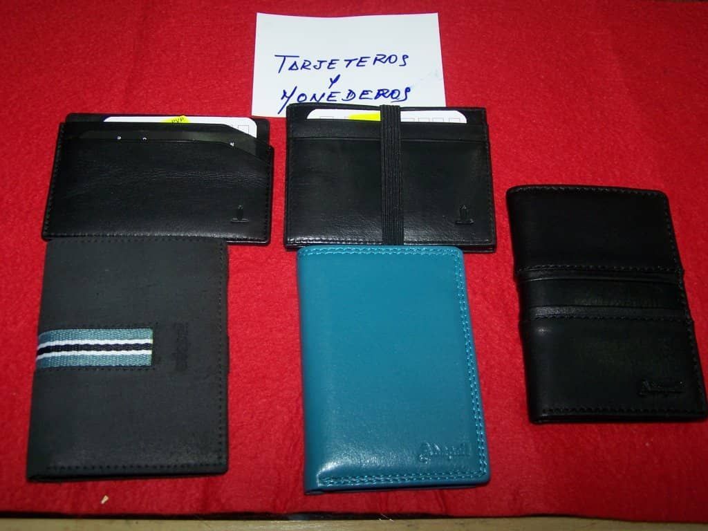 Varias carteras están alineadas sobre una mesa roja con una nota que dice 