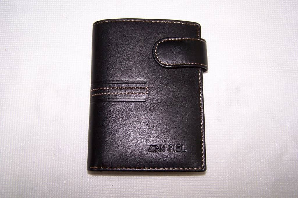 Una billetera negra con una costura blanca y la palabra snm en ella