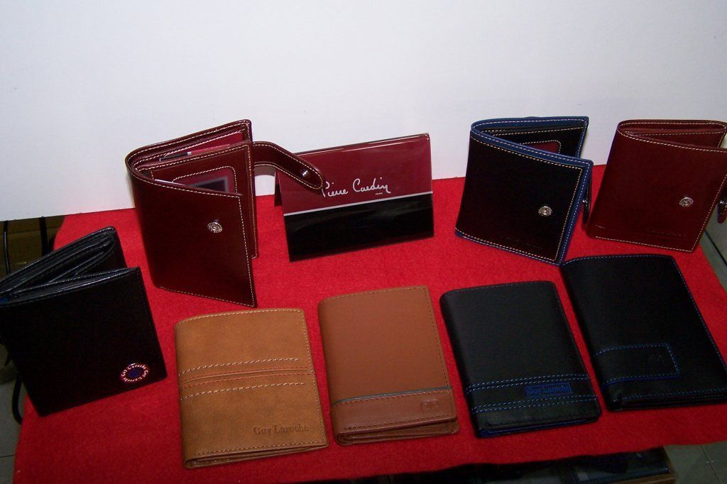 Varias carteras de diferentes colores están alineadas sobre una mesa