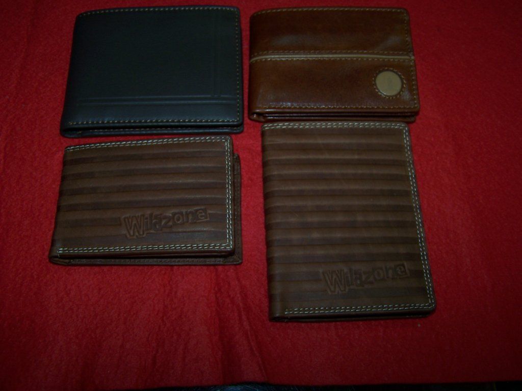 Cuatro carteras de diferentes colores se encuentran sobre una superficie roja.