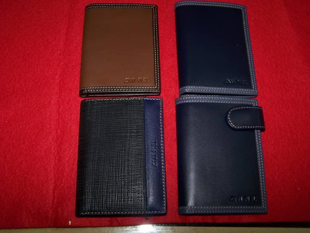 Cuatro carteras de diferentes colores están sobre una tela roja.