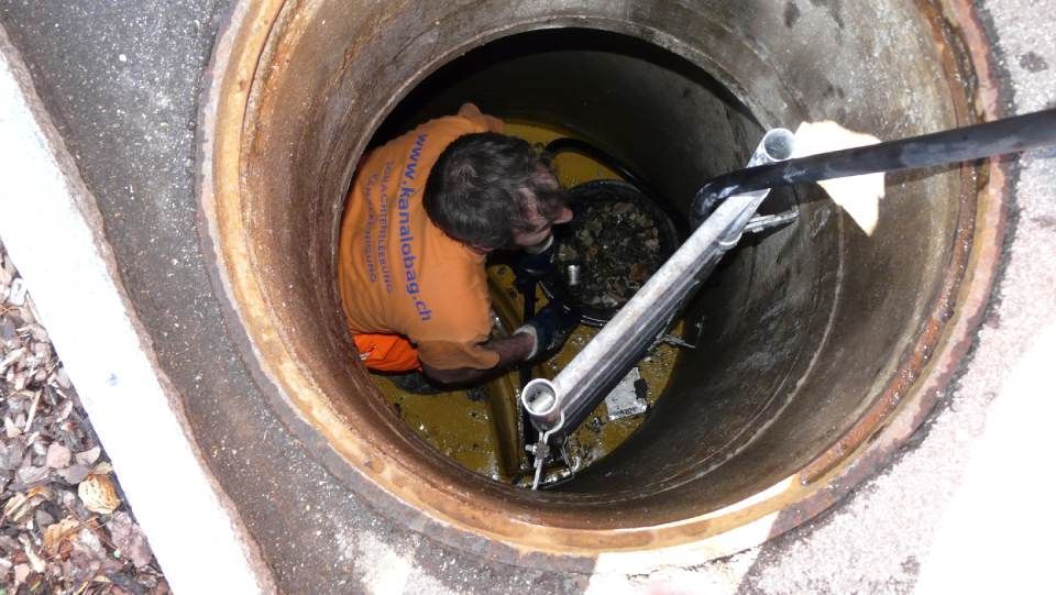 Mitarbeiter mit Werkzeugen in Kanalschacht, OBAG Kanalreinigung