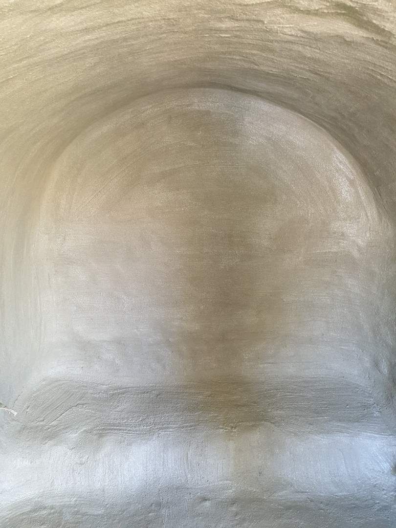 Une arche en plâtre vue de près, avec une finition lisse et uniforme. La texture du plâtre est visible.