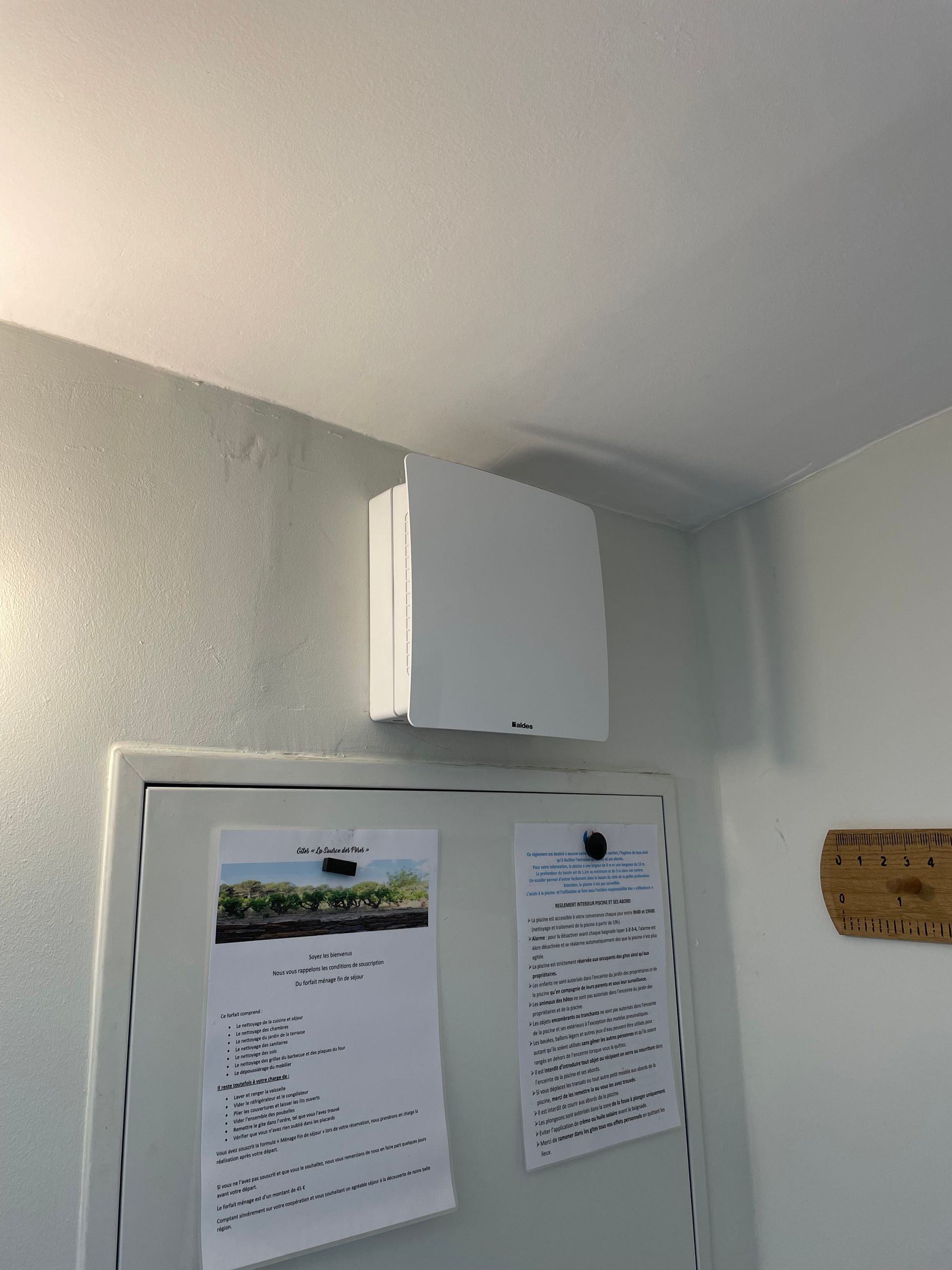 Boîtier électrique monté sur un mur avec des instructions et un petit appareil électronique à côté.