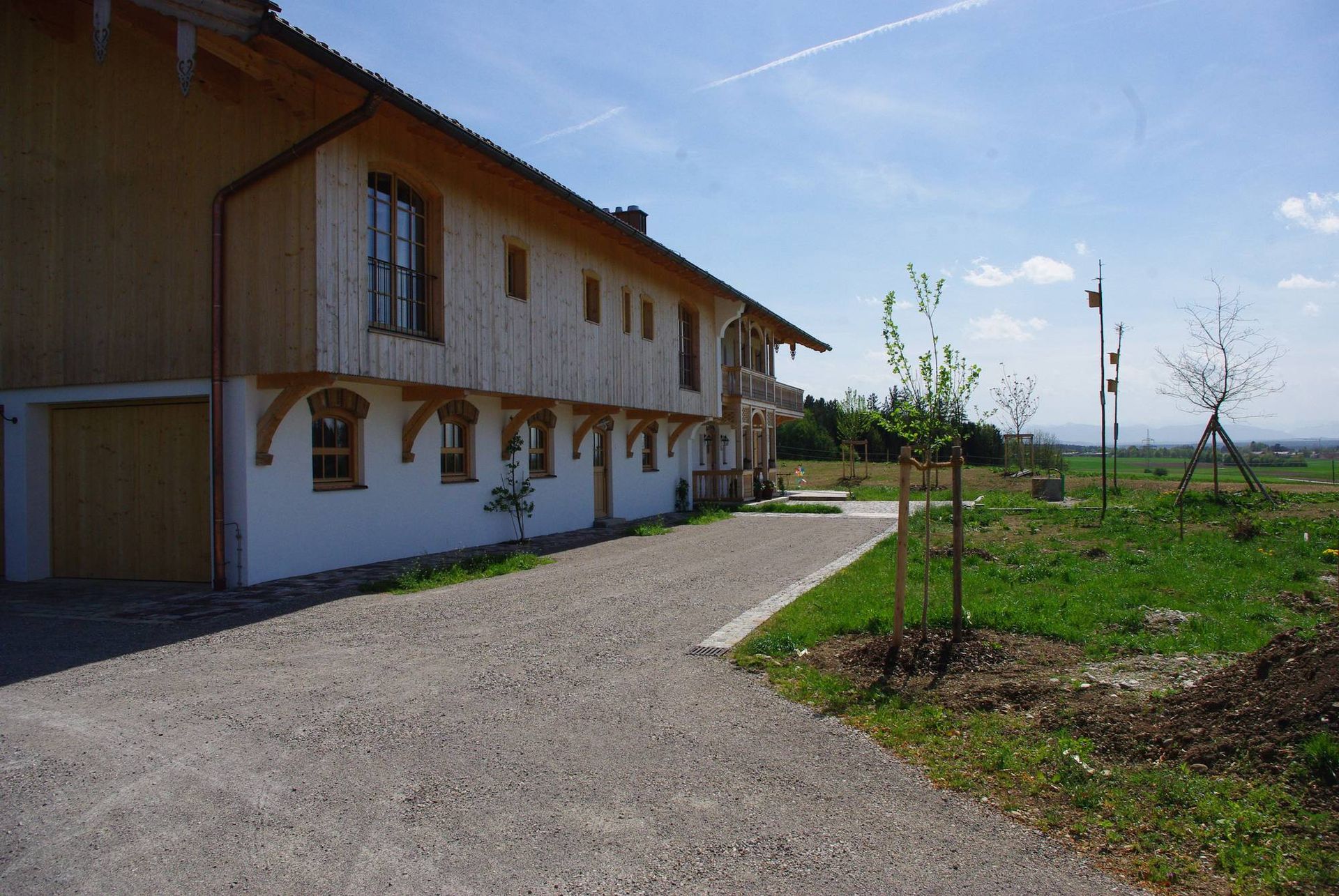 Langes Haus auf dem Land mit Holzfassade in der oberen Etage