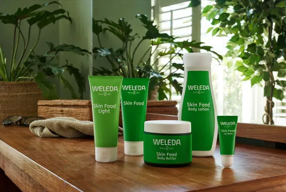 Una mesa con botellas de cosméticos Weleda encima.