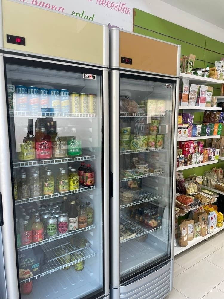 Un refrigerador en una tienda lleno de mucha comida y bebidas.