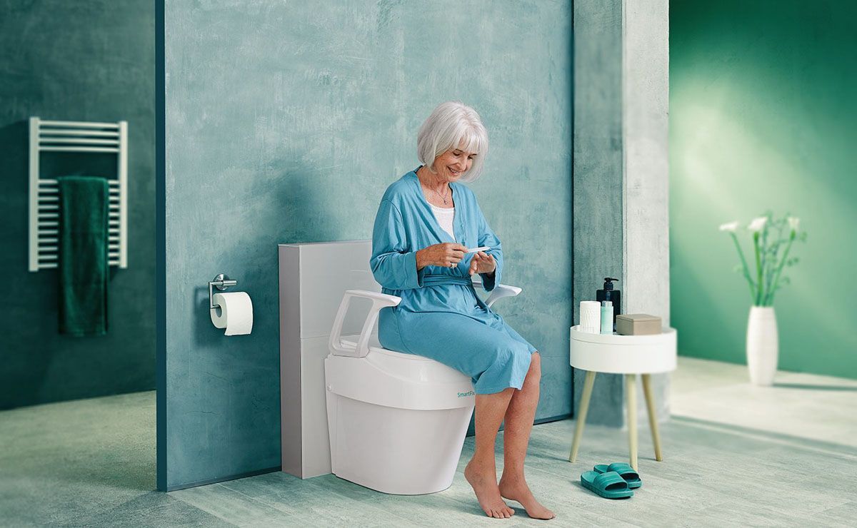 Eine ältere Frau sitzt auf einer Toilette in einem Badezimmer.