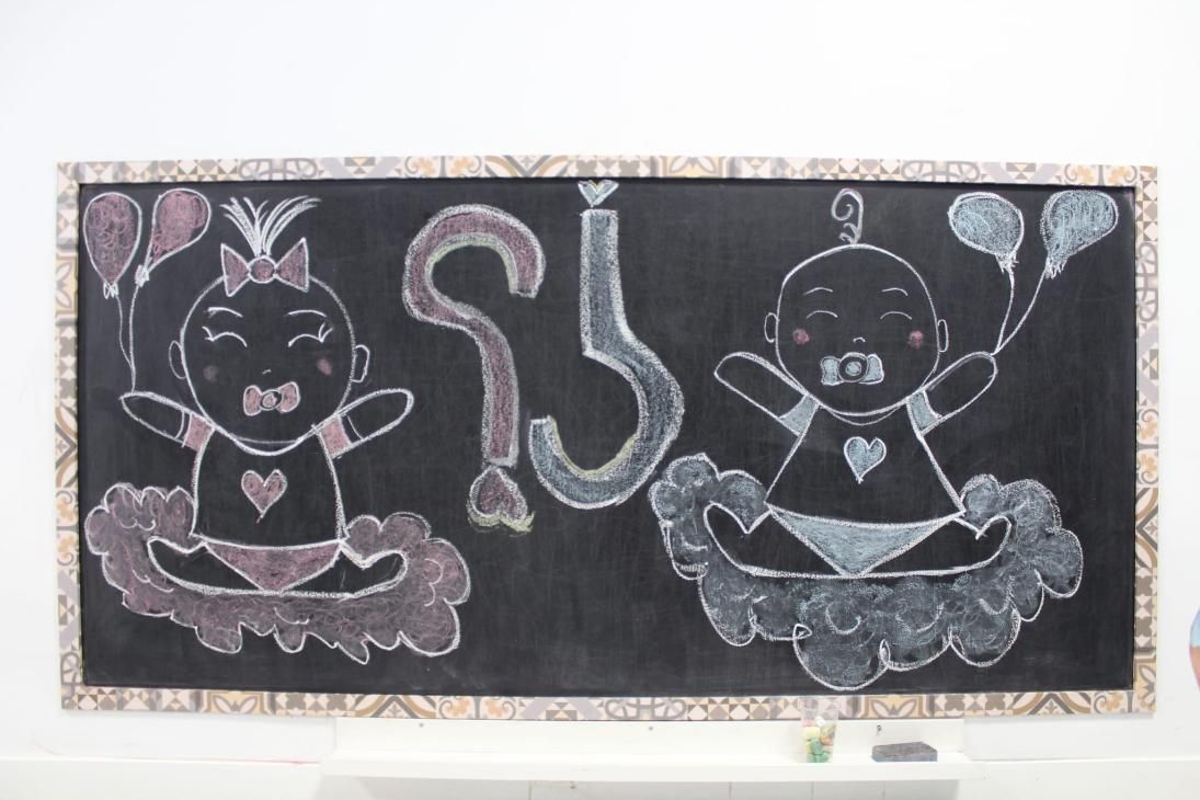 Arte de pizarra: Dos bebés con globos, camisetas con corazones y un número 2. 