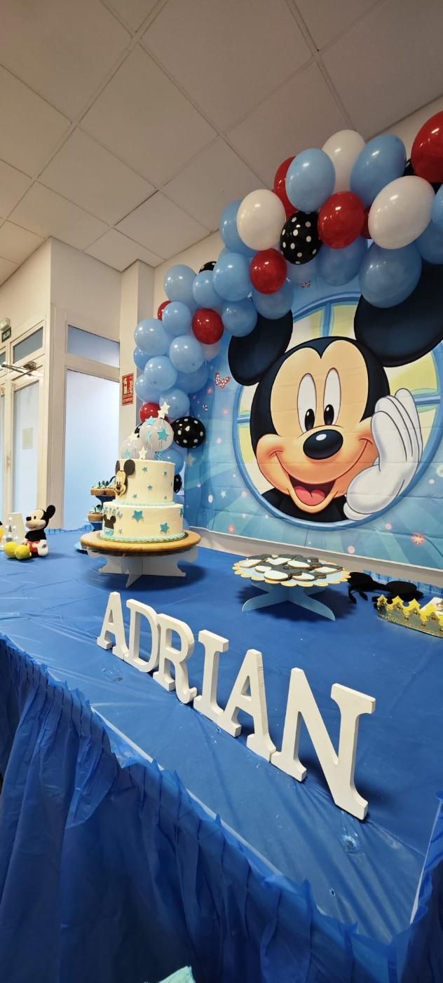 Fiesta de cumpleaños temática de Mickey Mouse con pastel, globos y el nombre 