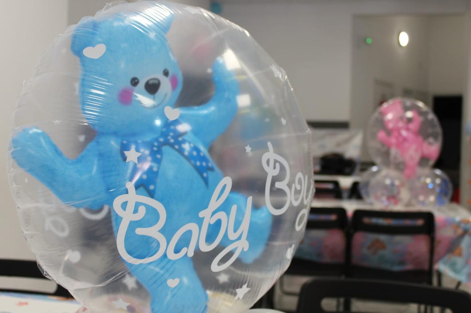 Globo de osito de peluche azul dentro de un globo transparente, texto 