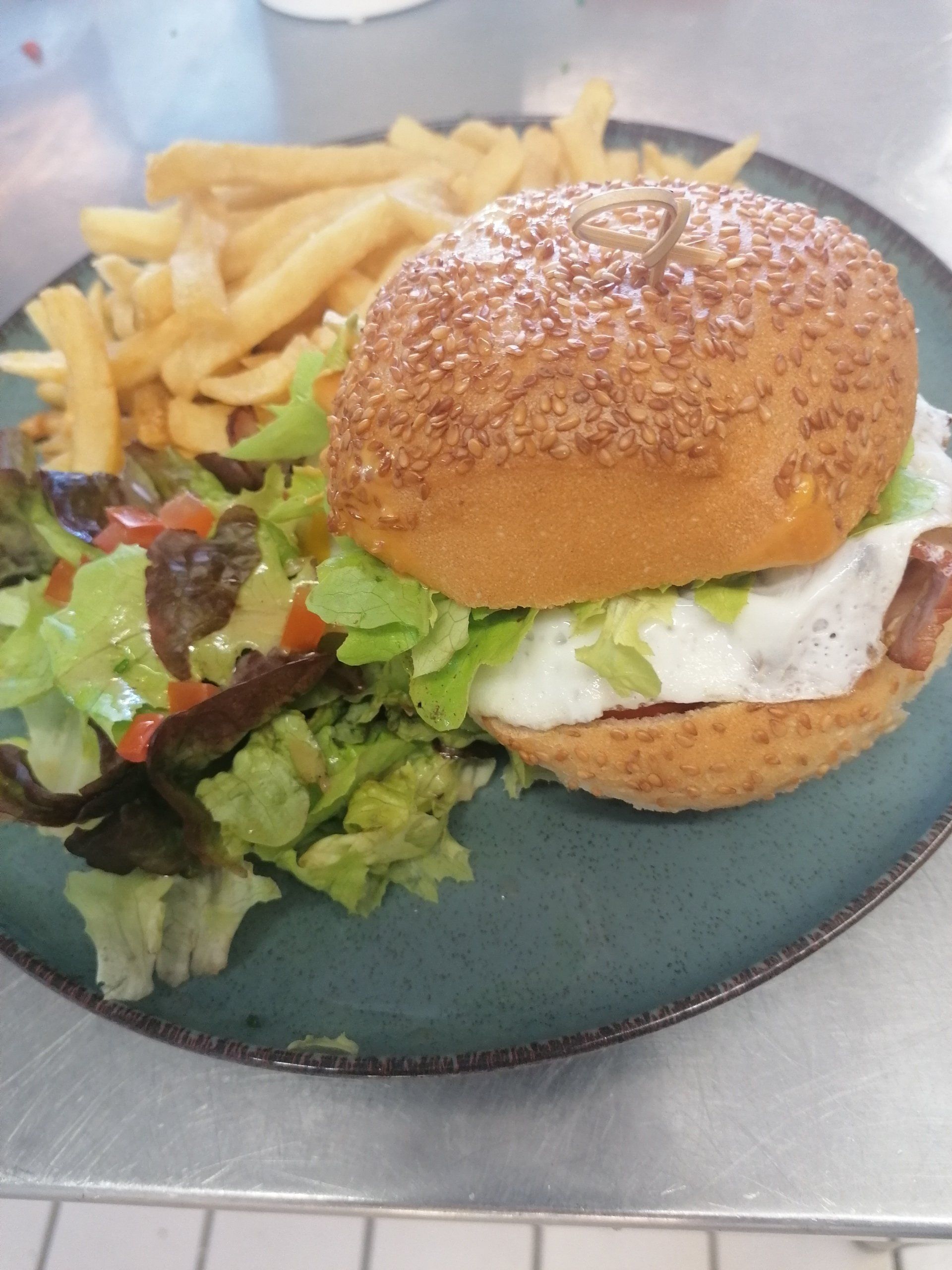 Un burger avec des frites et de la salade
