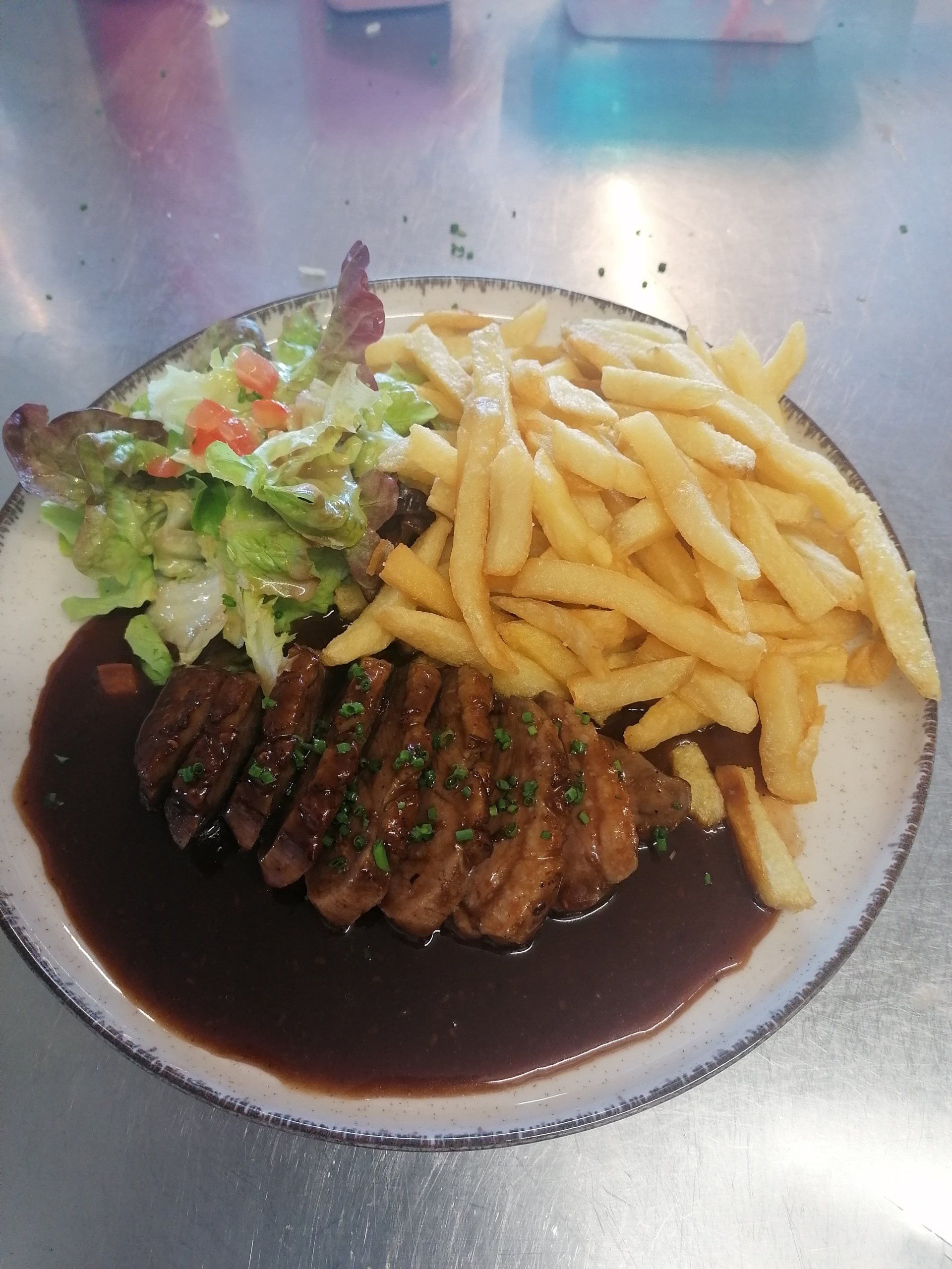 Un morceau de viande avec des frites et de la salade
