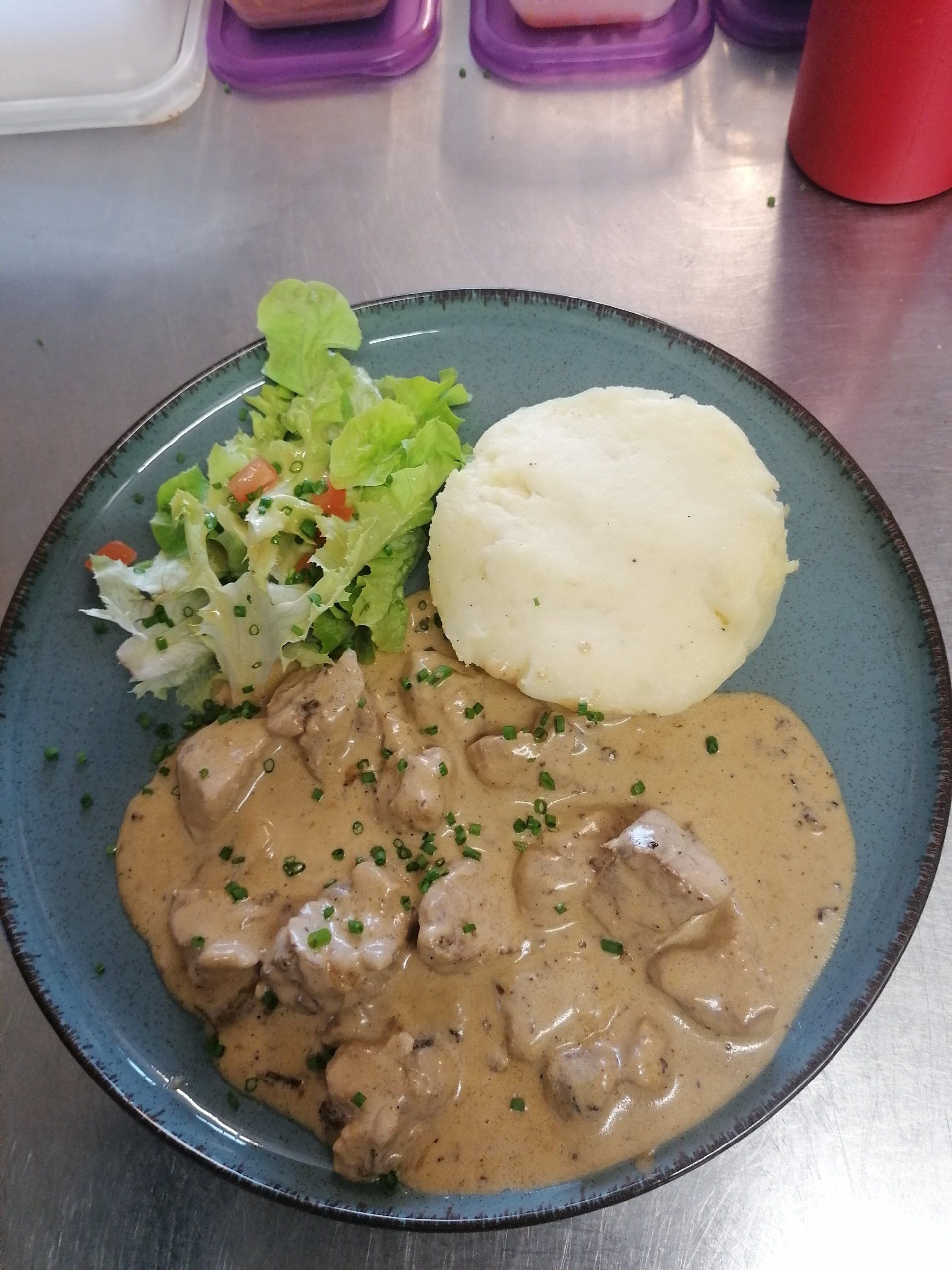 De la viande en sauce avec une purée et de la salade