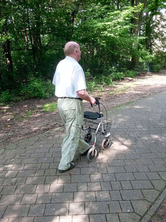 Mann mit Gehwagen