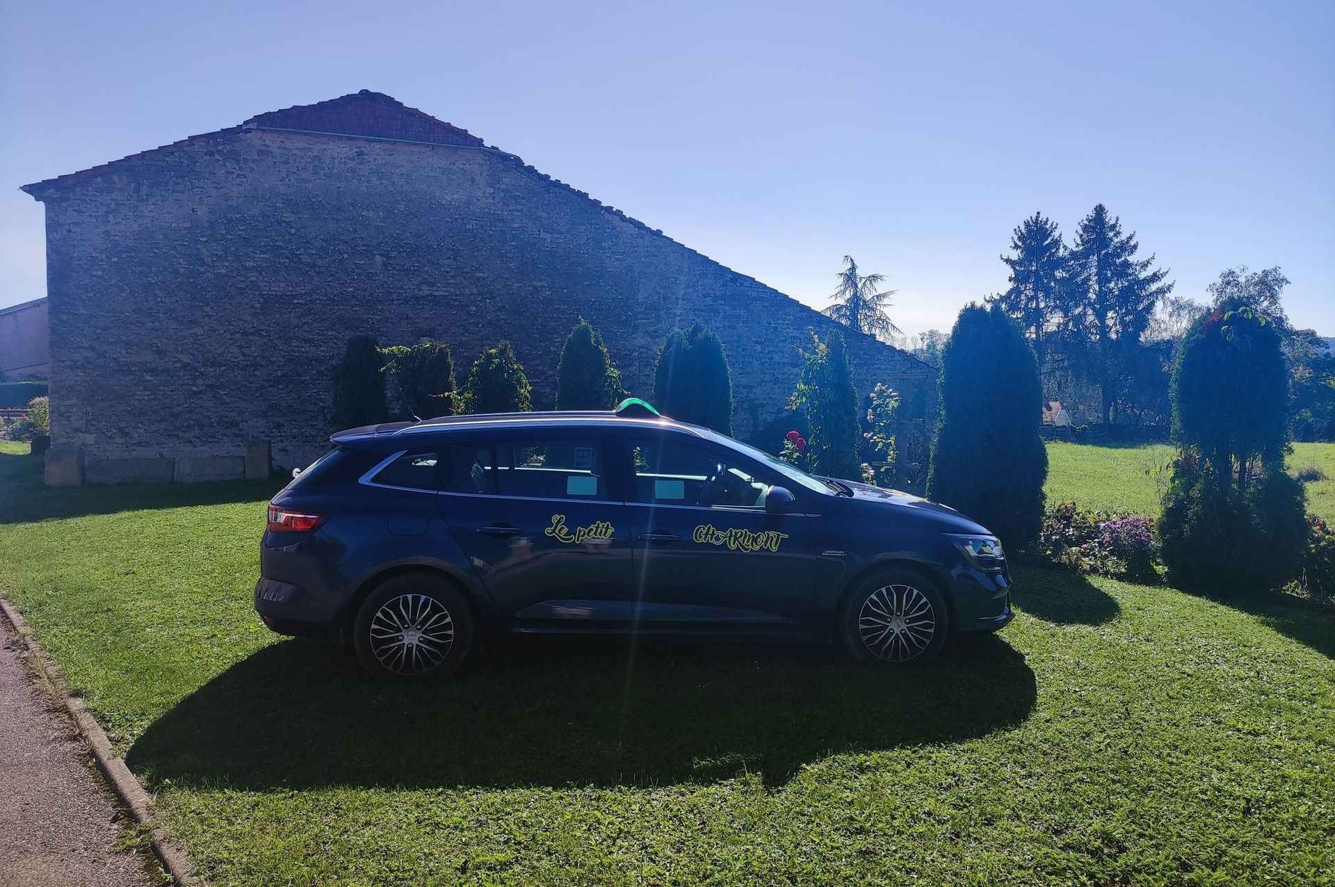 Une voiture en contre jour garée sur une pelouse