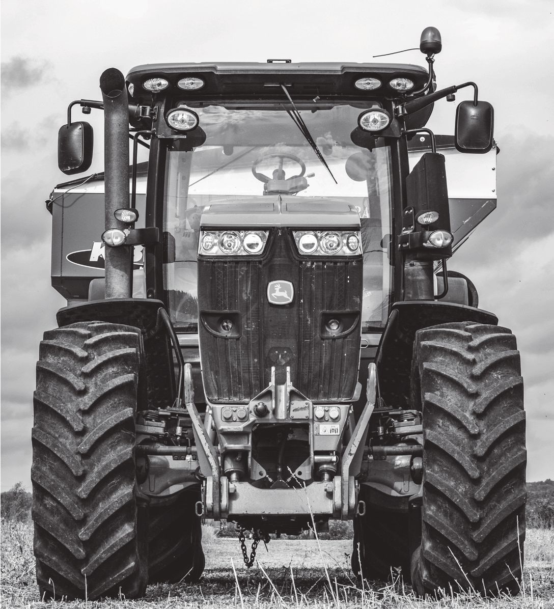 Una fotografía en blanco y negro de un tractor John Deere en un campo.