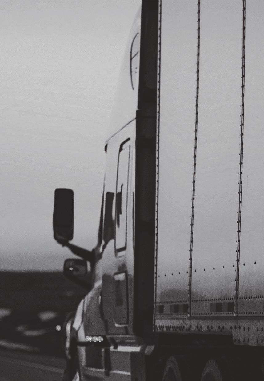 Una fotografía en blanco y negro de un camión semirremolque con la letra f en el costado.