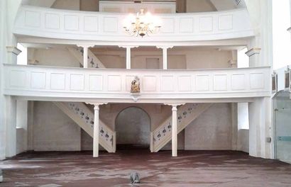 Eine leere Kirche mit Balkon und Treppe