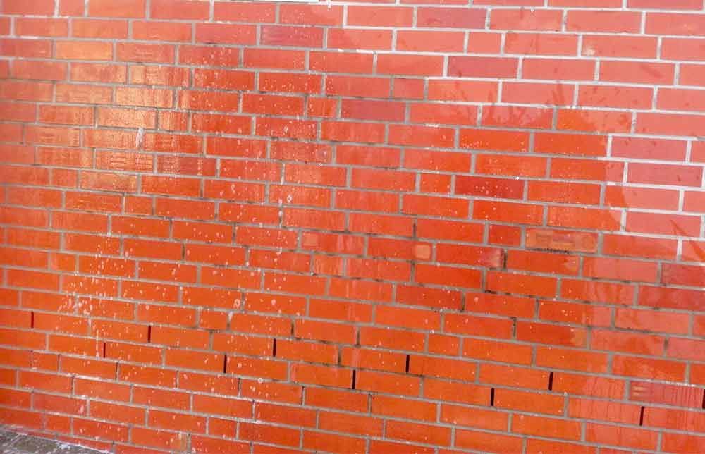 Eine Nahaufnahme einer roten Backsteinmauer.