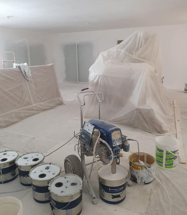 De nombreux pots de peinture au sol.