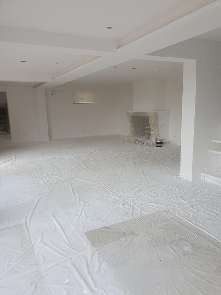 Un artisan avec un rouleau de peinture blanche.