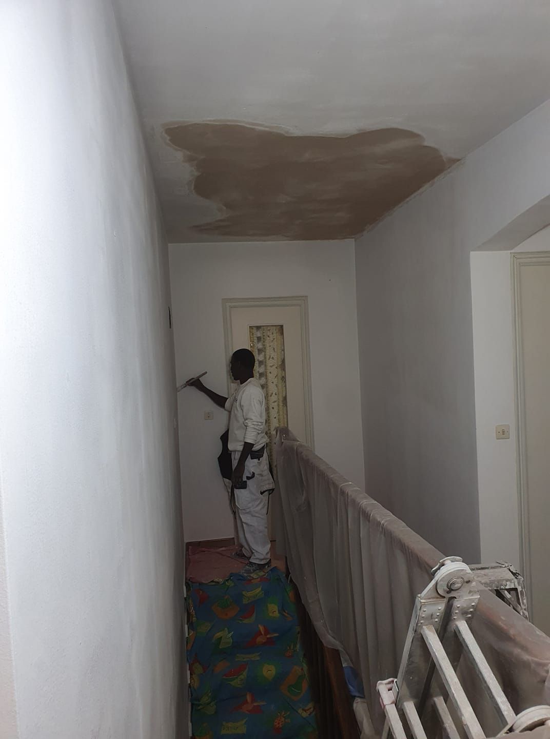 Un artisan pose un film au plafond.