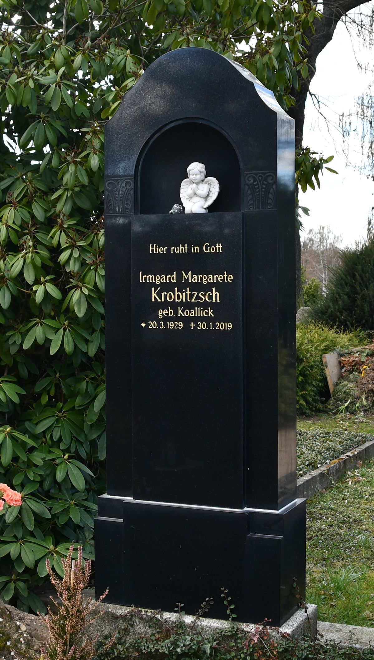 JH Steingestaltung, großes schwarzes Grabmal mit kleiner Skulptur