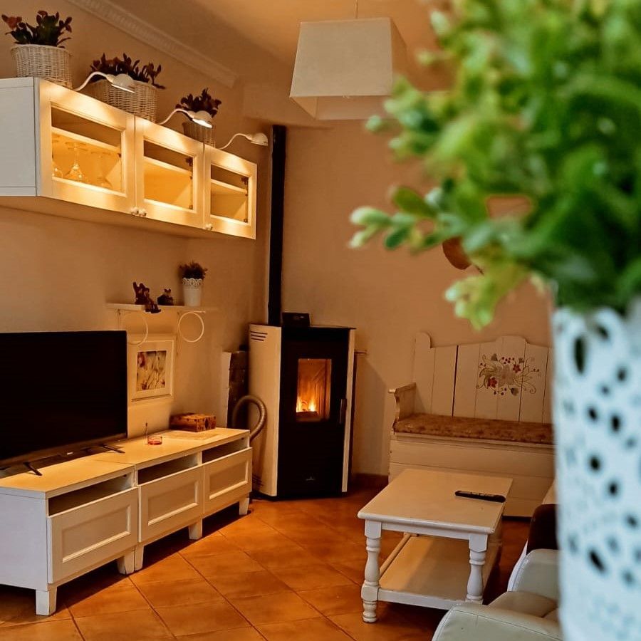 Un jarrón con flores rosas y blancas está sobre una mesa en una sala de estar.